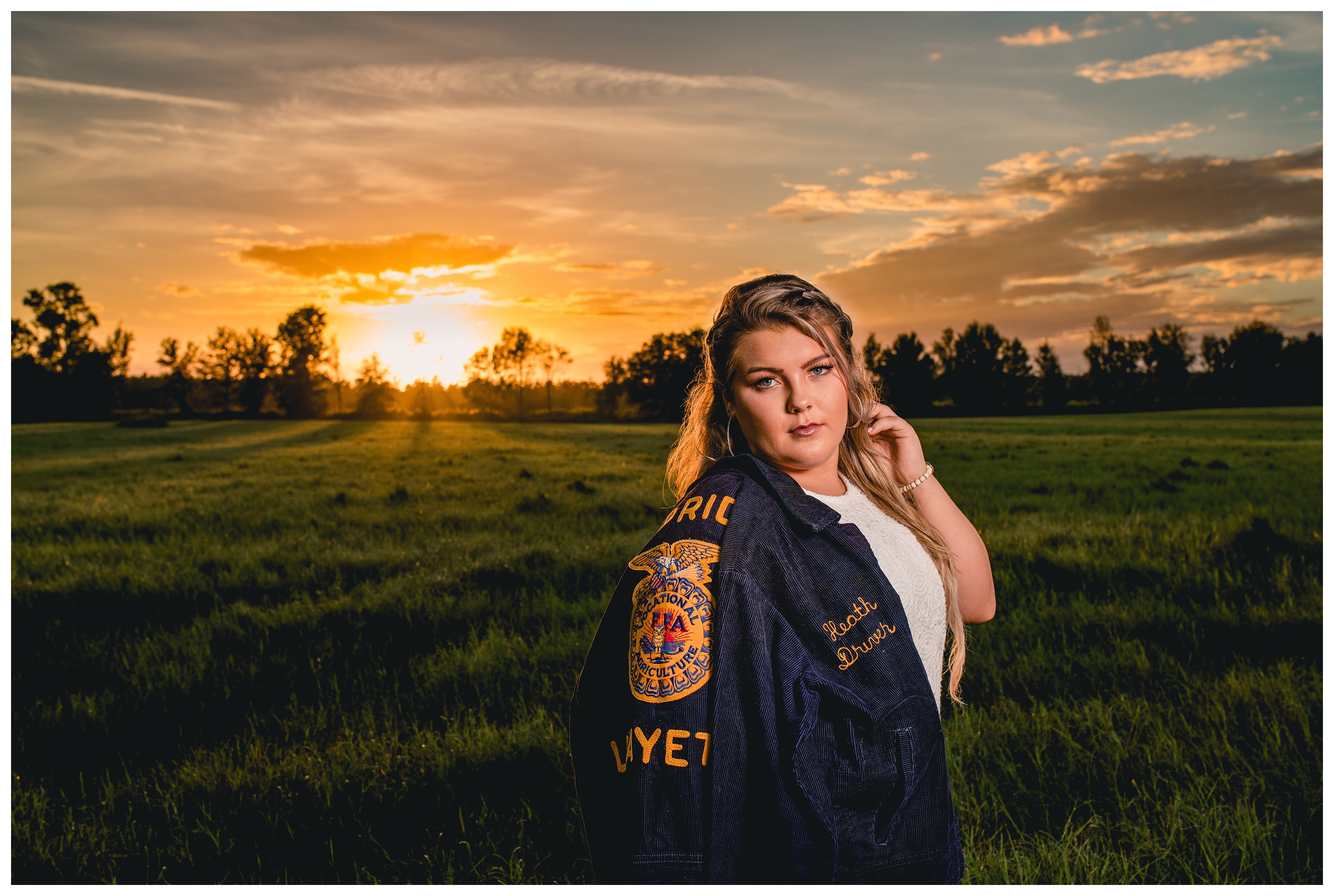 Sunset photos of high school senior girl with FFA jacket.